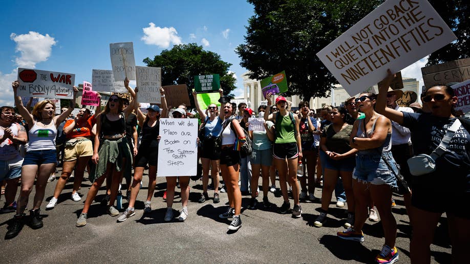 Protesters hold signs