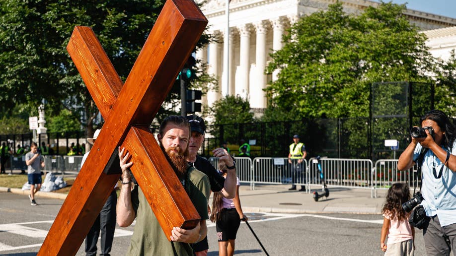 Man hold cross protesting Roe vs. Wade