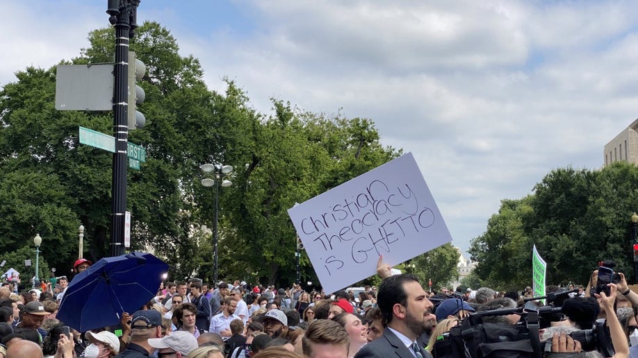 A sign reading, 'Christian Theocracy is Gheto'