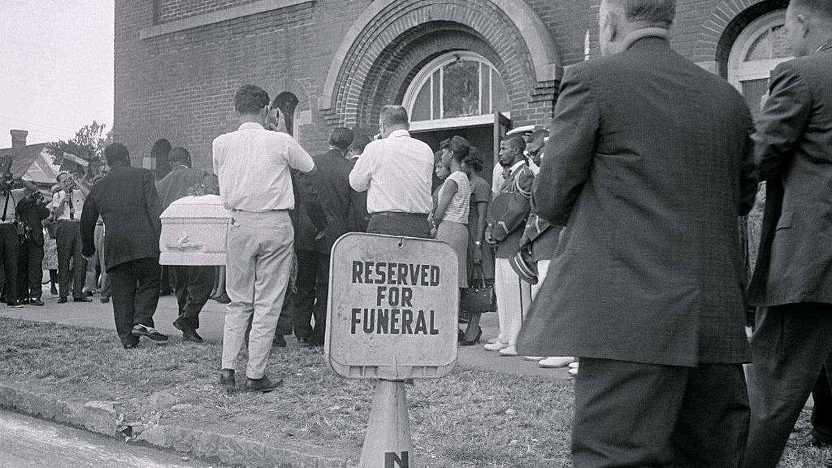 ARCHIVAL IMAGE – (Original Caption) Birmingham: A white casket containing the body of 14-year-old Carol Robertson, one of four young Negroes killed here early morning when a dynamite bomb exploded in the basement of the 16th Street Baptist Church, is carried into a Negro church here this afternoon for funeral services. Carol is the first of the youngsters to be buried. (Getty Images)