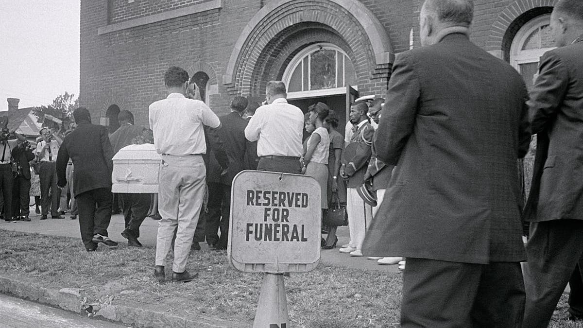 ARCHIVAL IMAGE – (Original Caption) Birmingham: A white casket containing the body of 14-year-old Carol Robertson, one of four young Negroes killed here early morning when a dynamite bomb exploded in the basement of the 16th Street Baptist Church, is carried into a Negro church here this afternoon for funeral services. Carol is the first of the youngsters to be buried. (Getty Images)