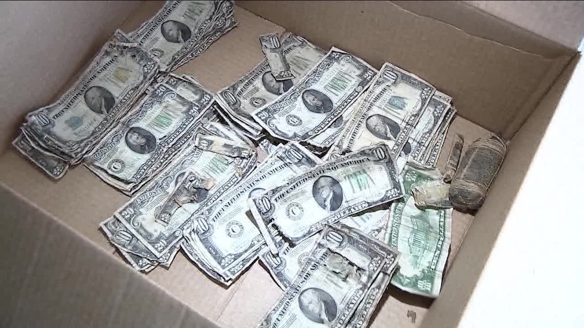  crumpled up cash in a cardboard box