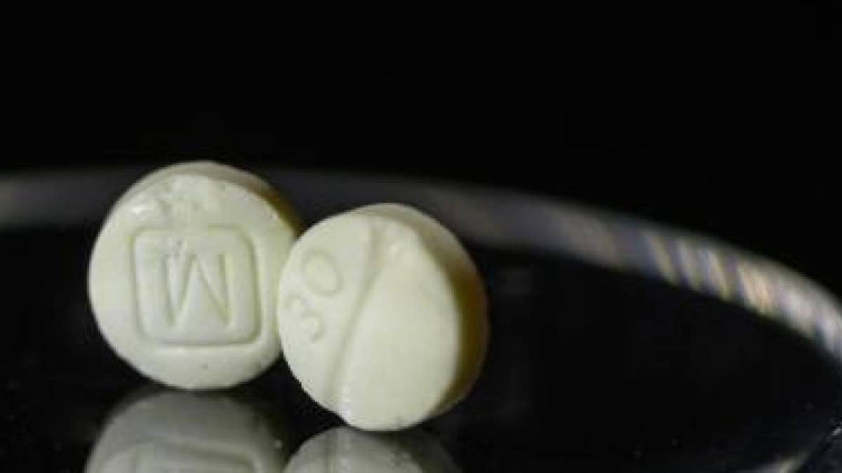 A pill watermarked to look like oxy, but it's fake and likely laced with fentanyl