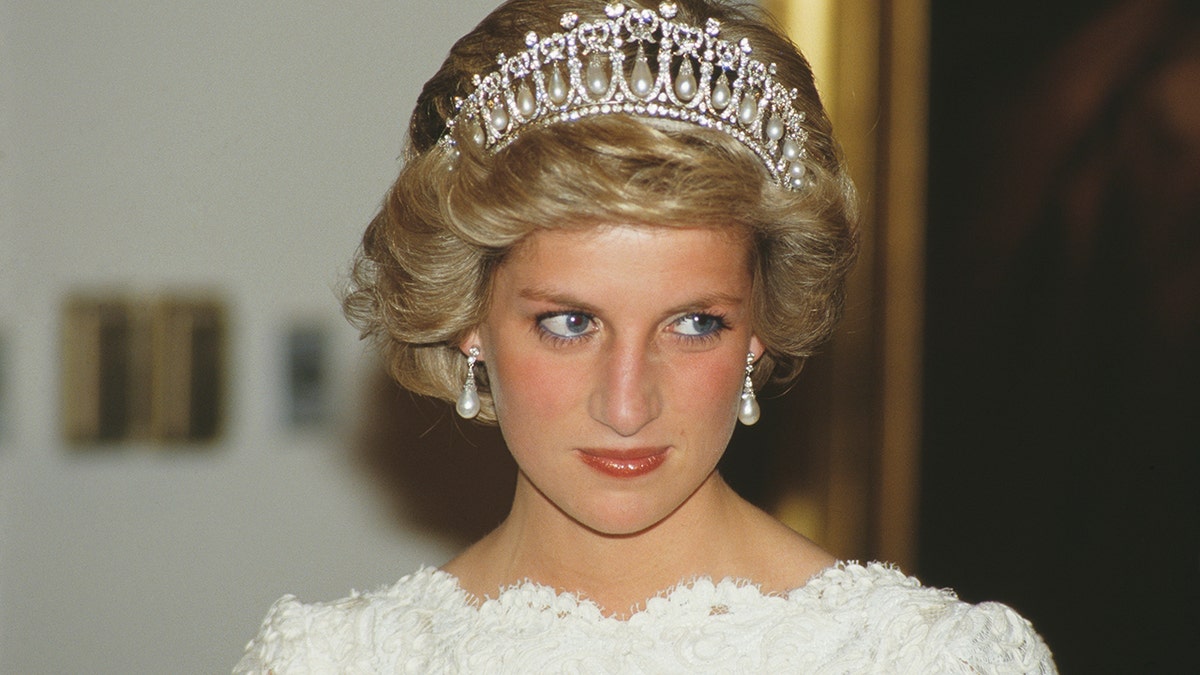 Princess Diana wearing the lover's knot tiara in a white dress looks off camera