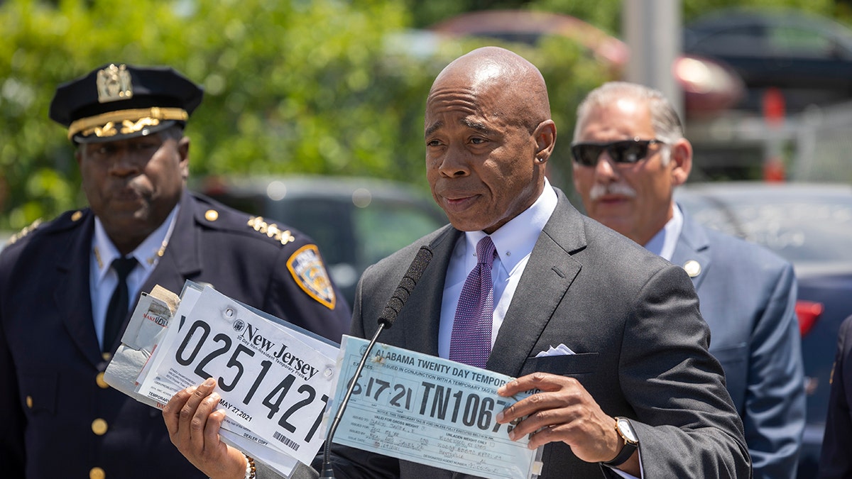 eric adams holds license plates