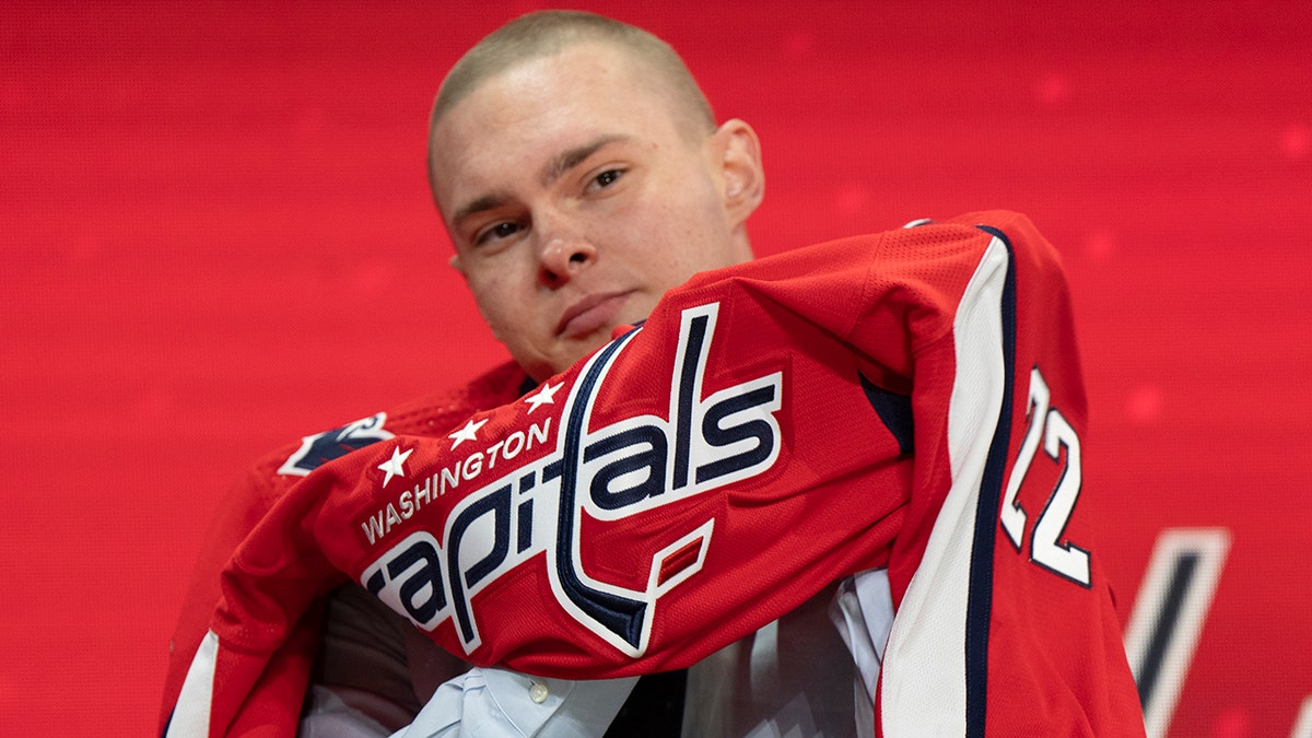 Ivan Miroshnichenko puts on a Caps jersey