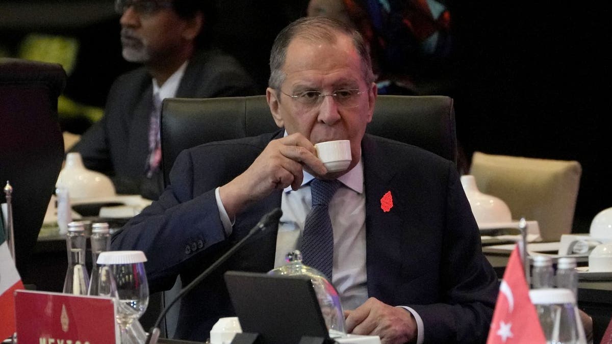 Russian Foreign Minister Sergei Lavrov sips a drinks at the G20