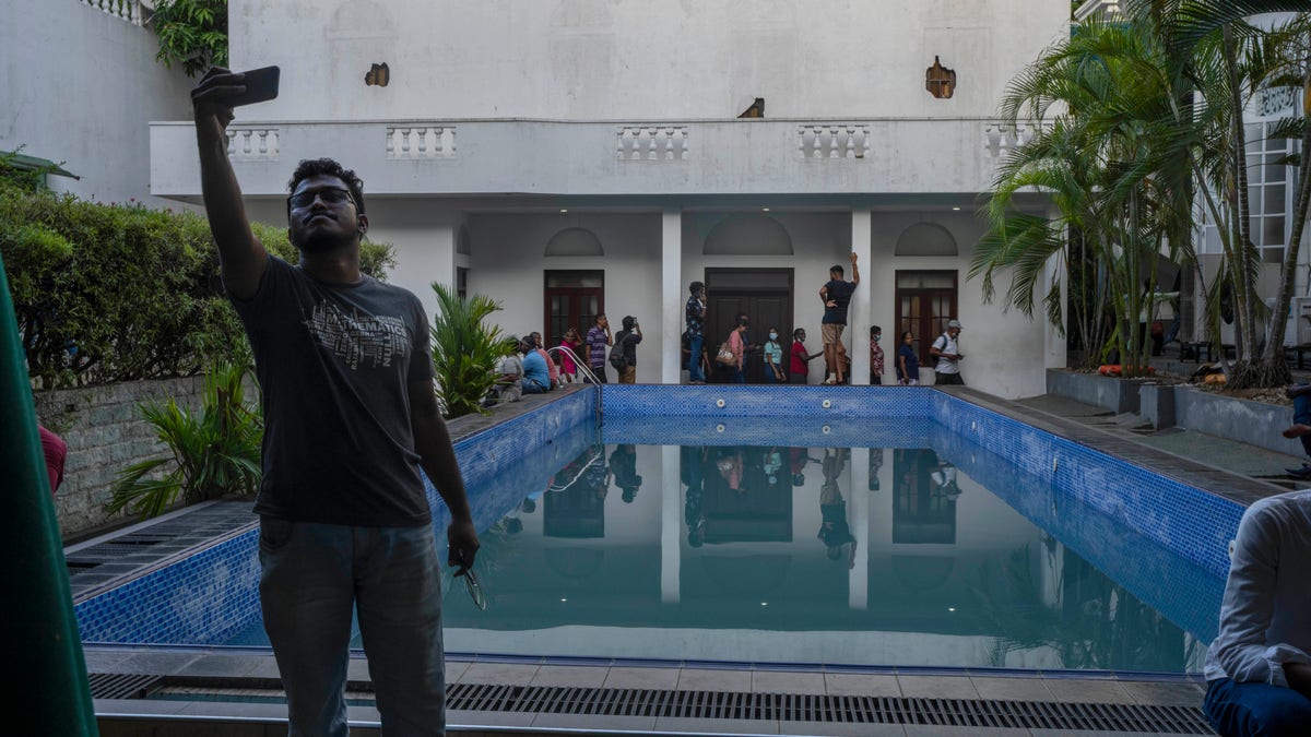 A protester takes a picture at the home of the president of Sri Lanka