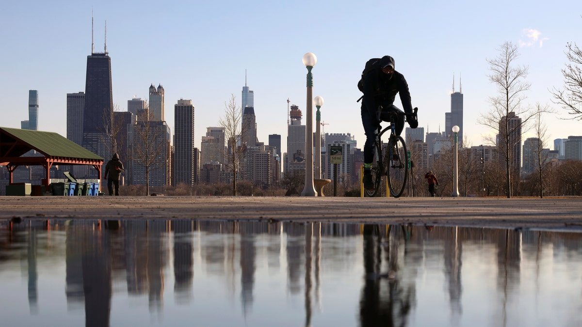 Photo showing biker riding in front of Chicago skyline 