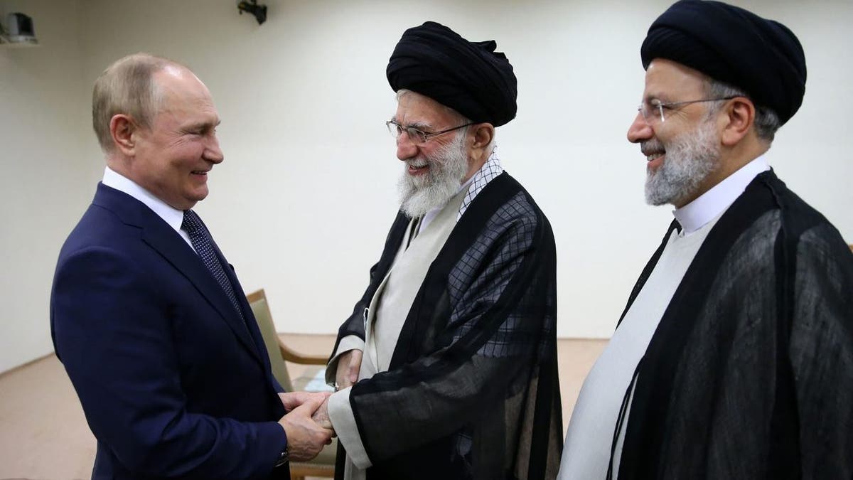 Russian President Vladimir Putin, smiling, shakes hands with Supreme Leader Ayatollah Ali Khamenei as Iranian President Ebrahim Raisi looks on