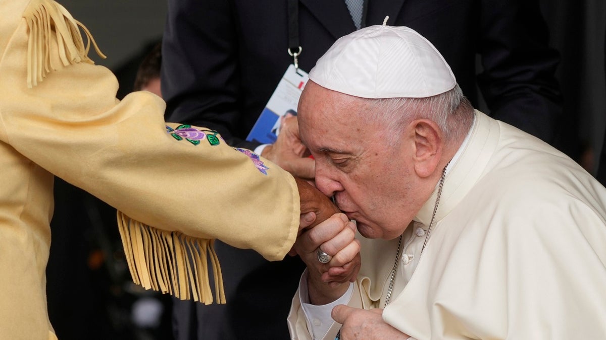 The pope kissing a hand