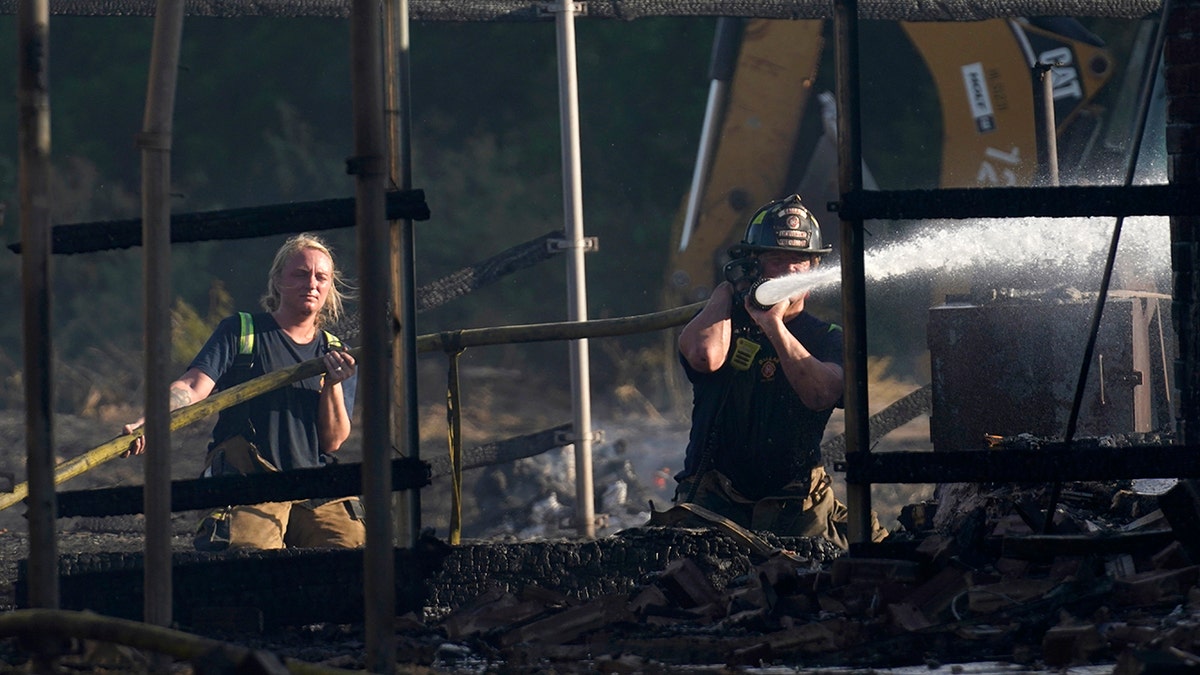 Two firefighters holding a water hose