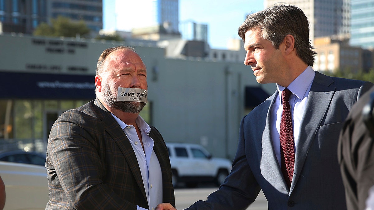 Alex Jones outside Texas courthouse with tape over mouth