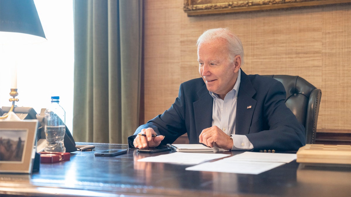 President Biden smiling at his desk
