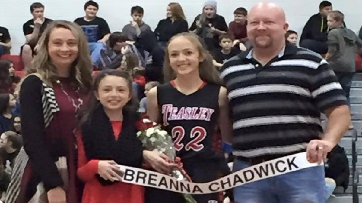 Breanna Chadwick in an athletic uniform with her family