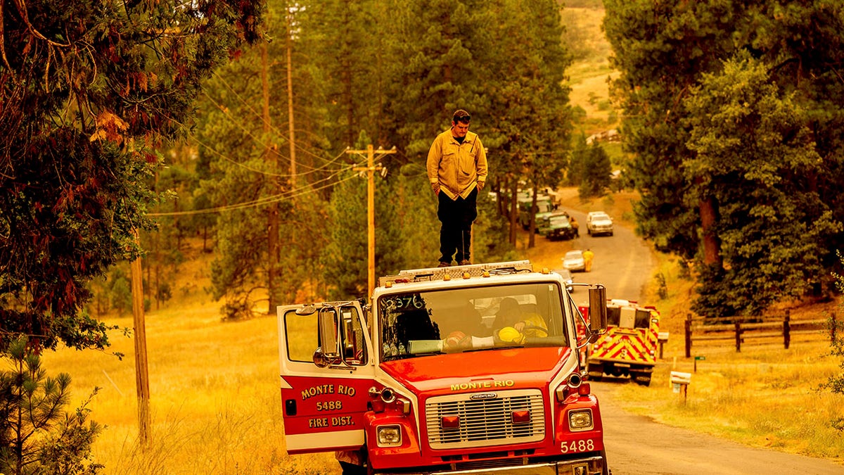 Firefighter standing on top of fire truck