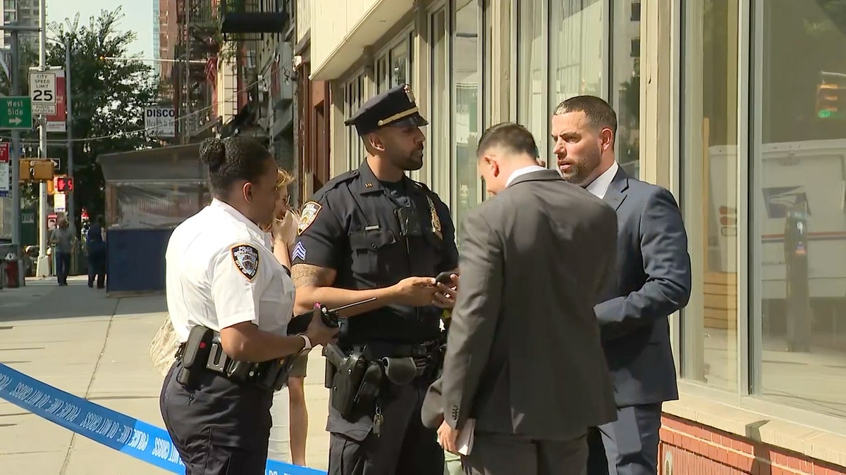 NYPD officer speaking with men wearing suits outside Chase bank