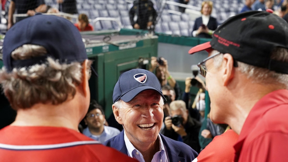 President Biden wearing a ballcap speaks with Republicans at the Congressional Baseball Game