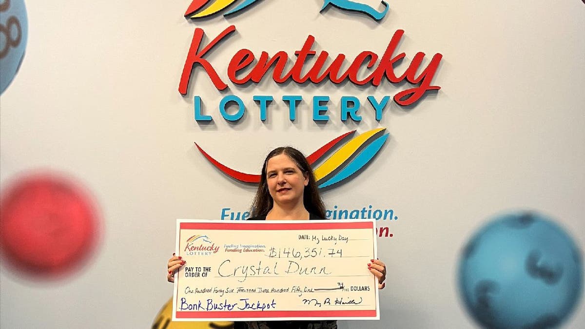 Crystal Dunn holds Kentucky Lottery check