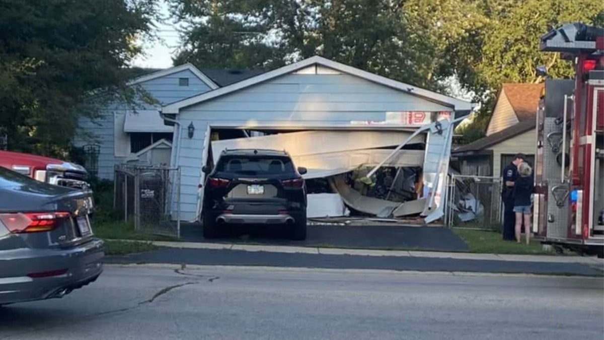 A garage that was heavily damaged after a person drove through it with their SUV