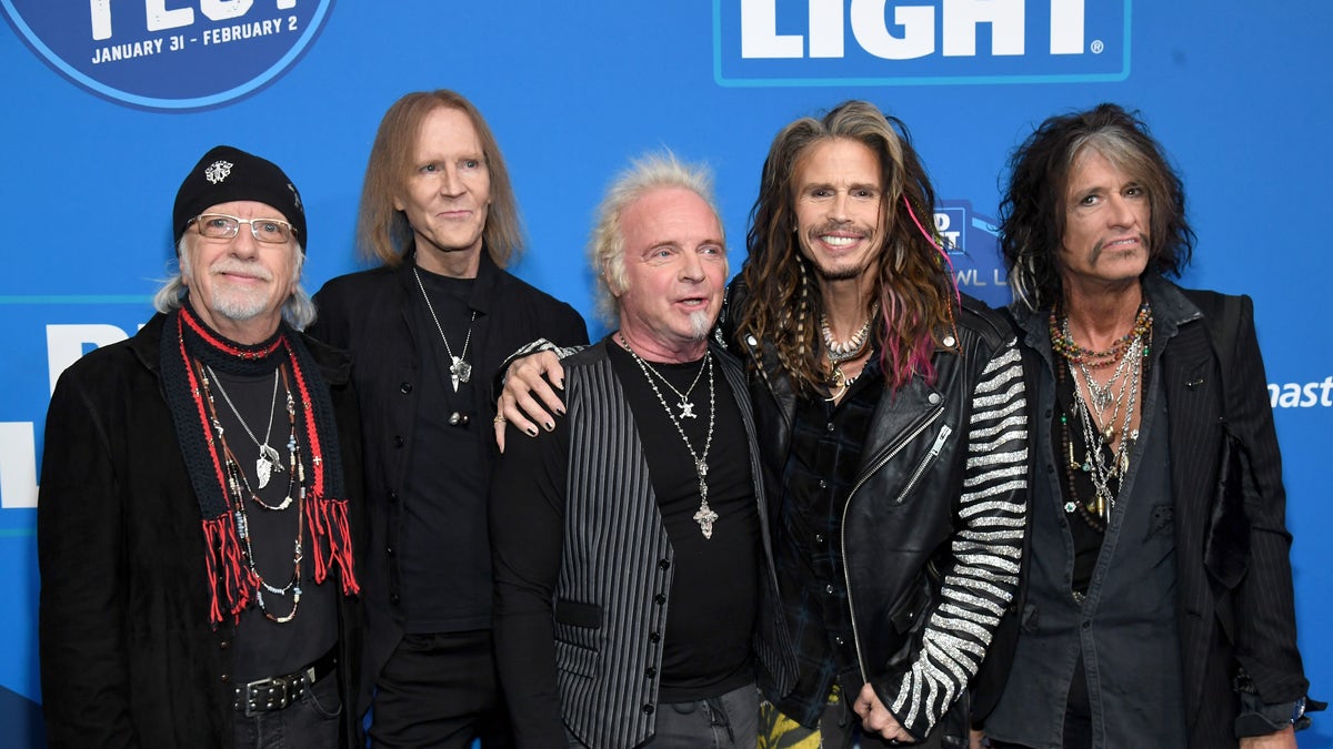 The band members of Aerosmith pose together for an event.