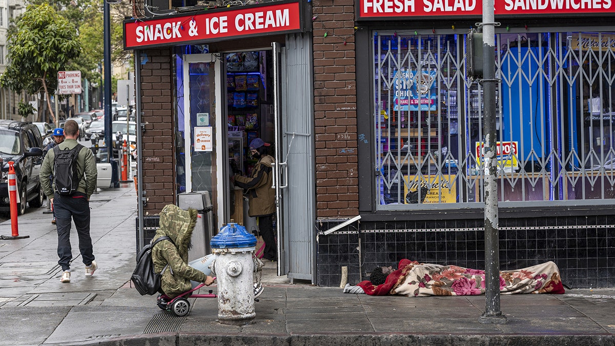 San Francisco homeless man sleeps on sidewalk