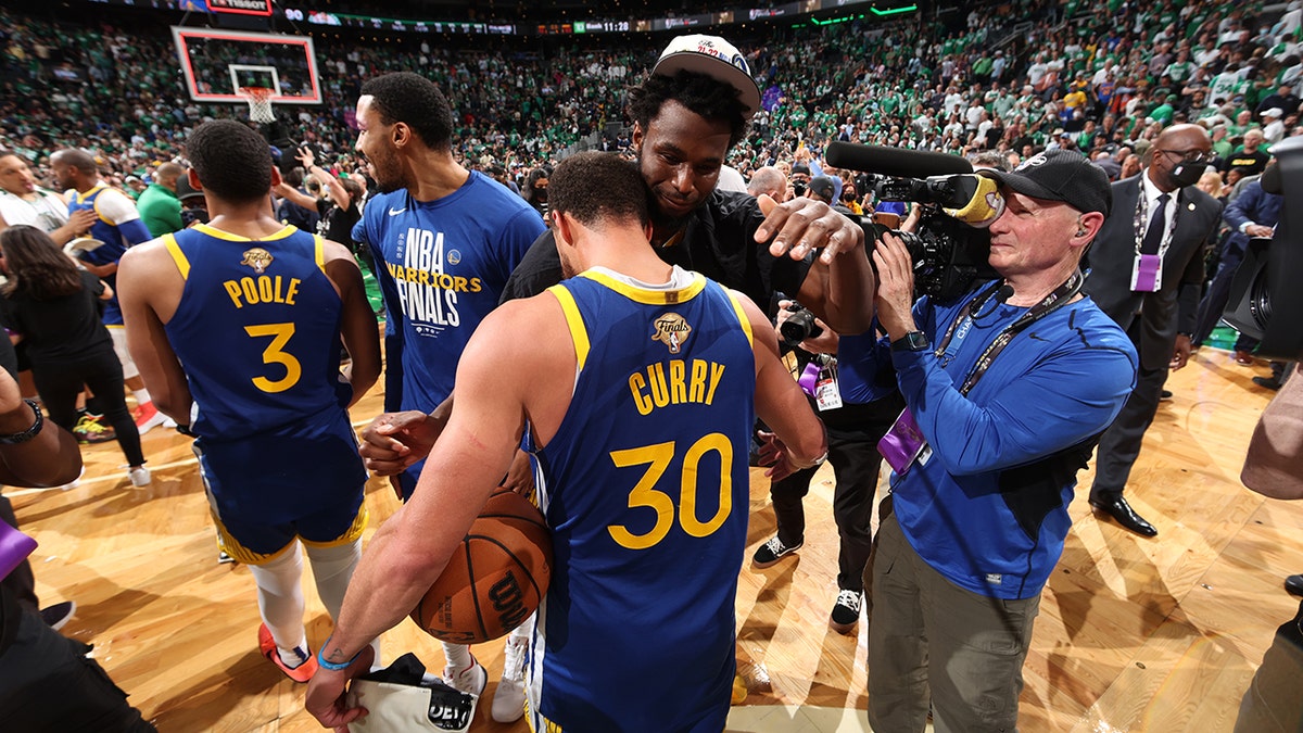 Stephen Curry and Andrew Wiggins hug after a game