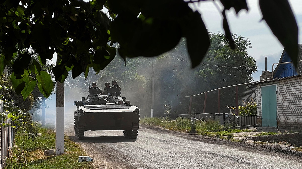 Ukrainian soldiers ride an armoured vehicle on the main road to Lysychansk in Ukraine's eastern region of Donbas on June 26, 2022.