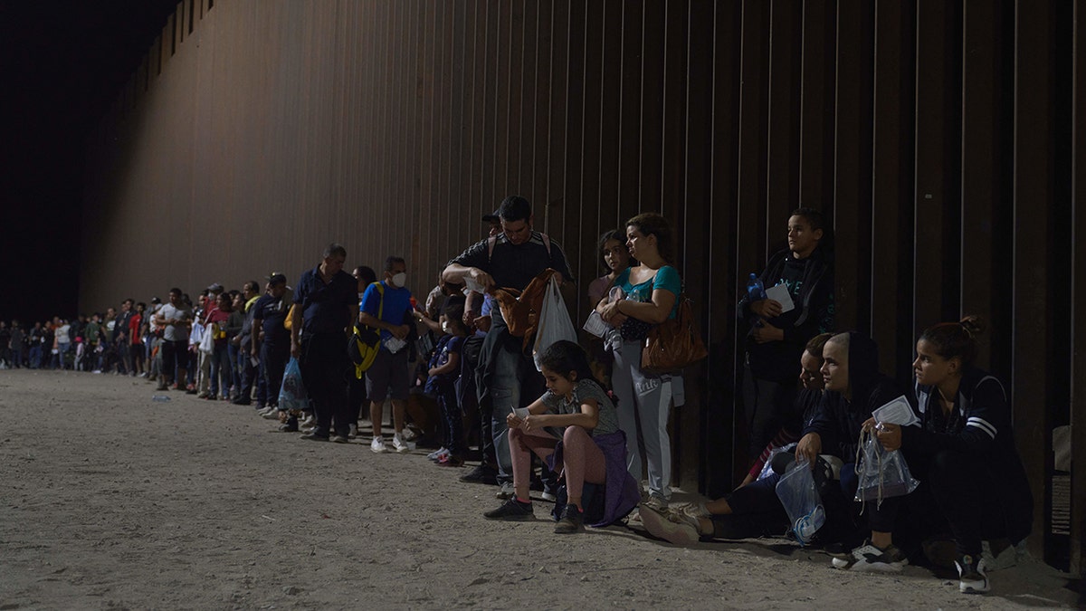 migrant adults and children at border fence