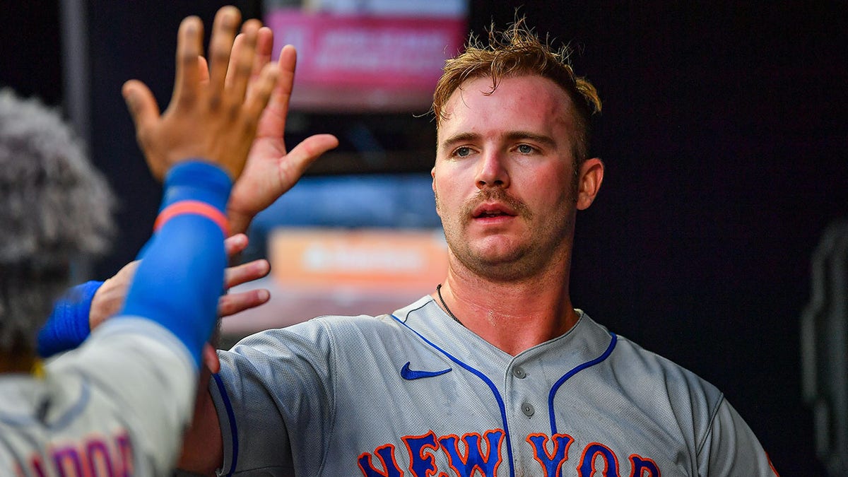 A sweaty Pete Alonso gives a high-five after a game