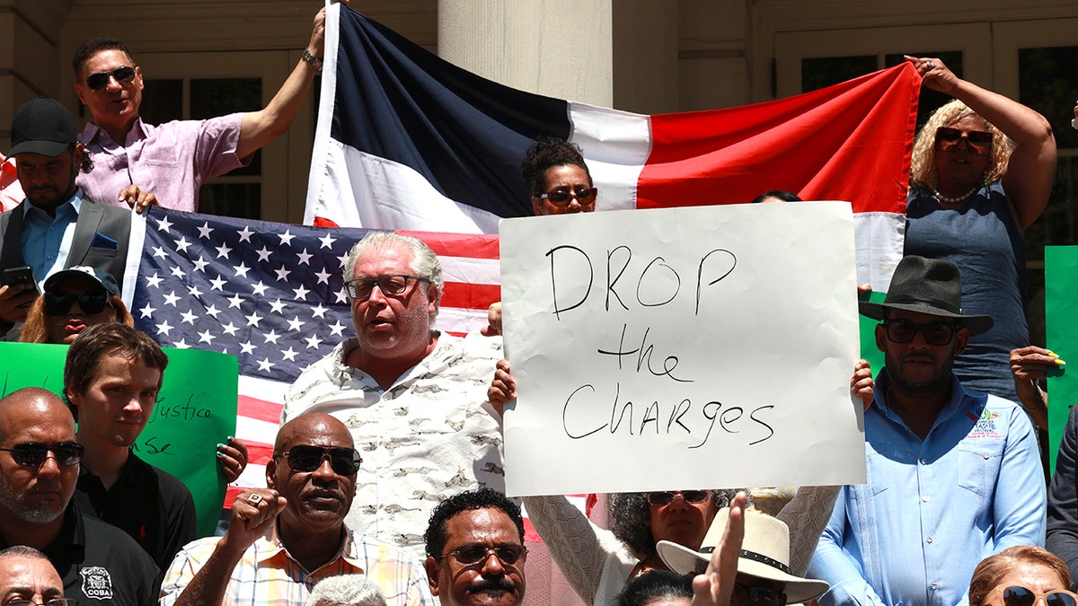 Jose Alba supporters with drop the charges sign