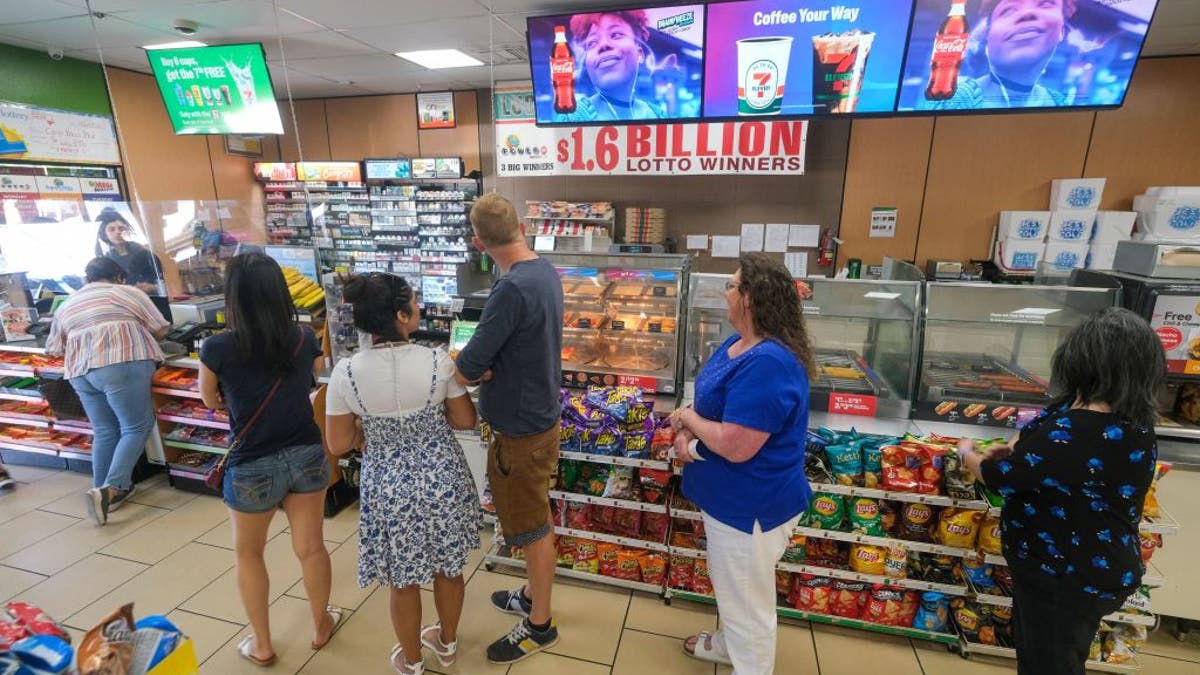 People wait in line to buy their lottery ticket