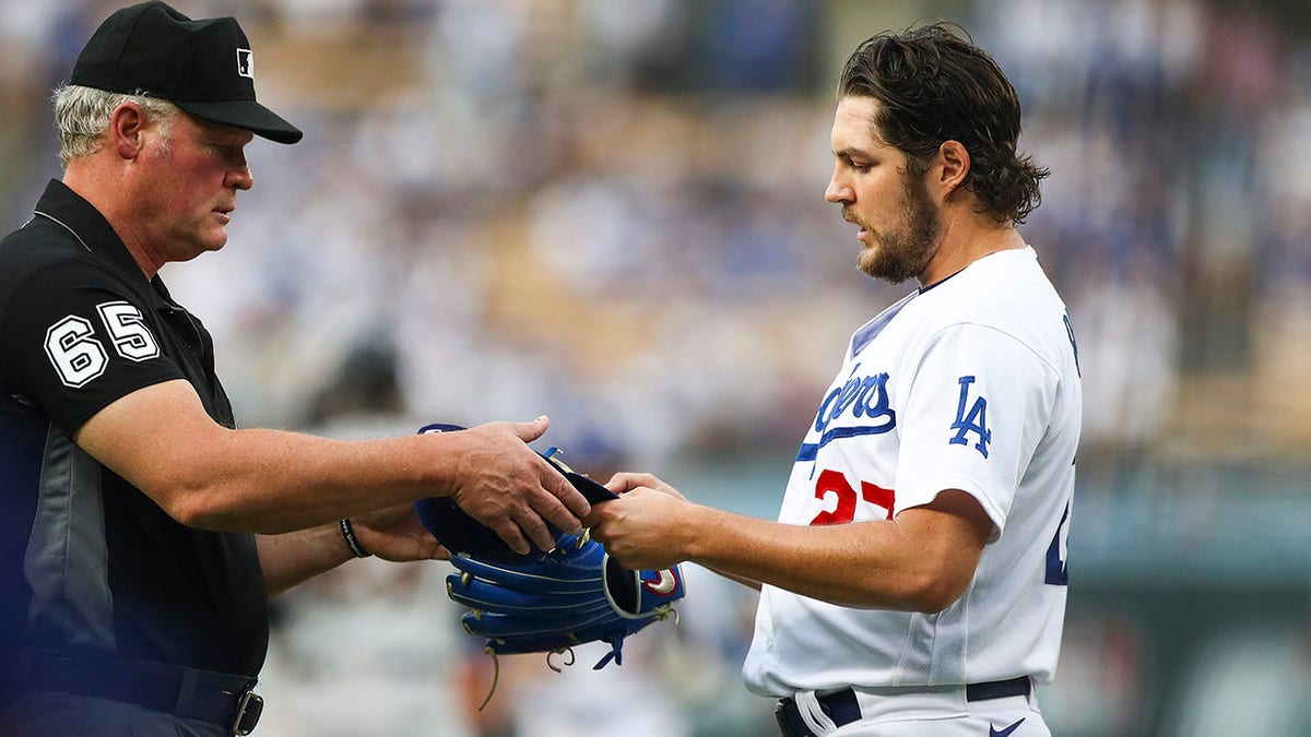 Dodgers pitcher Trevor Bauer has his glove checked by an umpire 