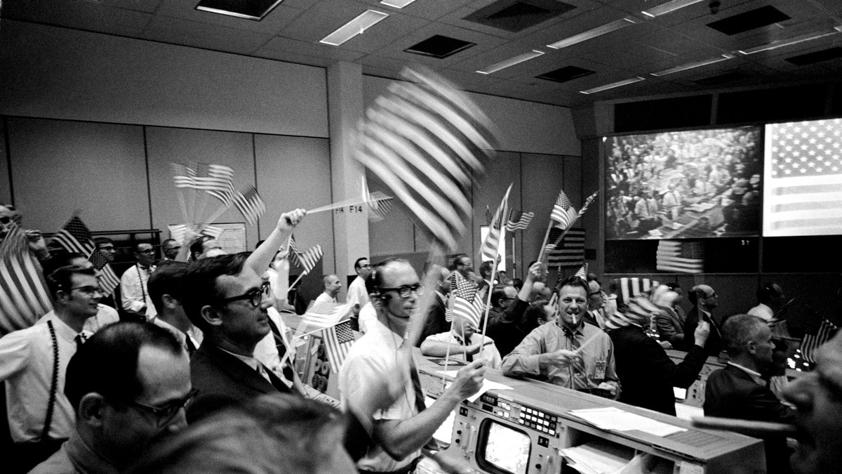 View of Mission Operations Control Room in the Mission Control Center (MCC), Manned Spacecraft Center (MSC), showing flight controllers celebrating successful conclusion of Apollo 11 mission. 