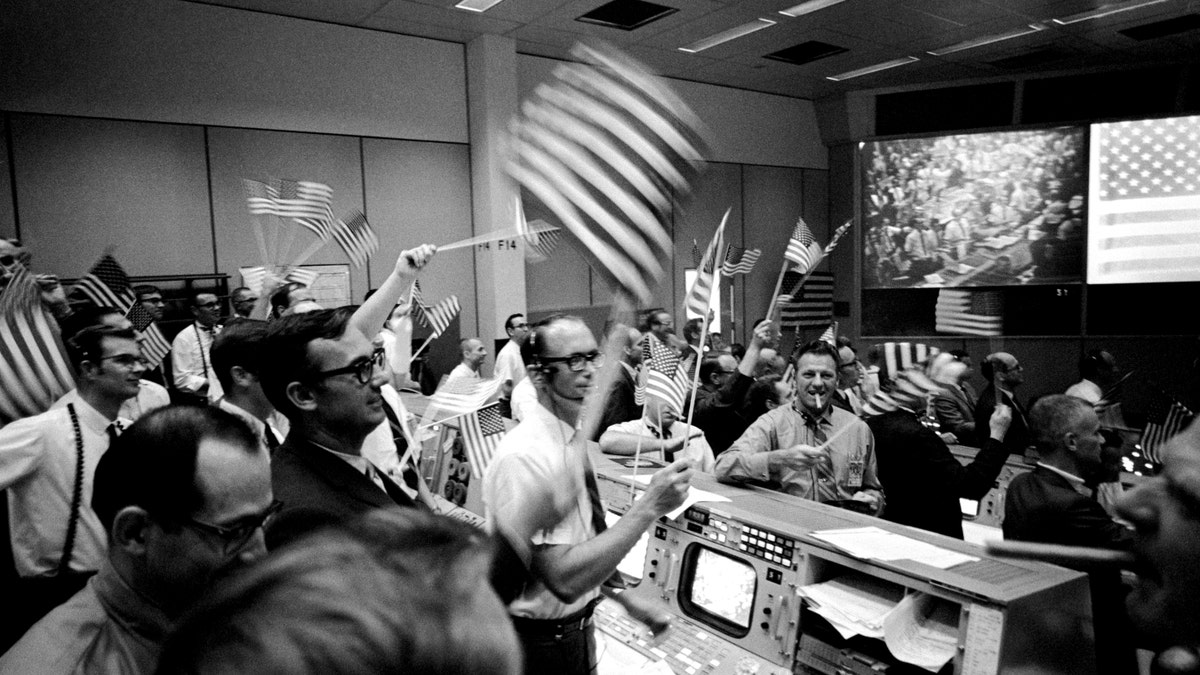 View of Mission Operations Control Room in the Mission Control Center (MCC), Manned Spacecraft Center (MSC), showing flight controllers celebrating successful conclusion of Apollo 11 mission.?