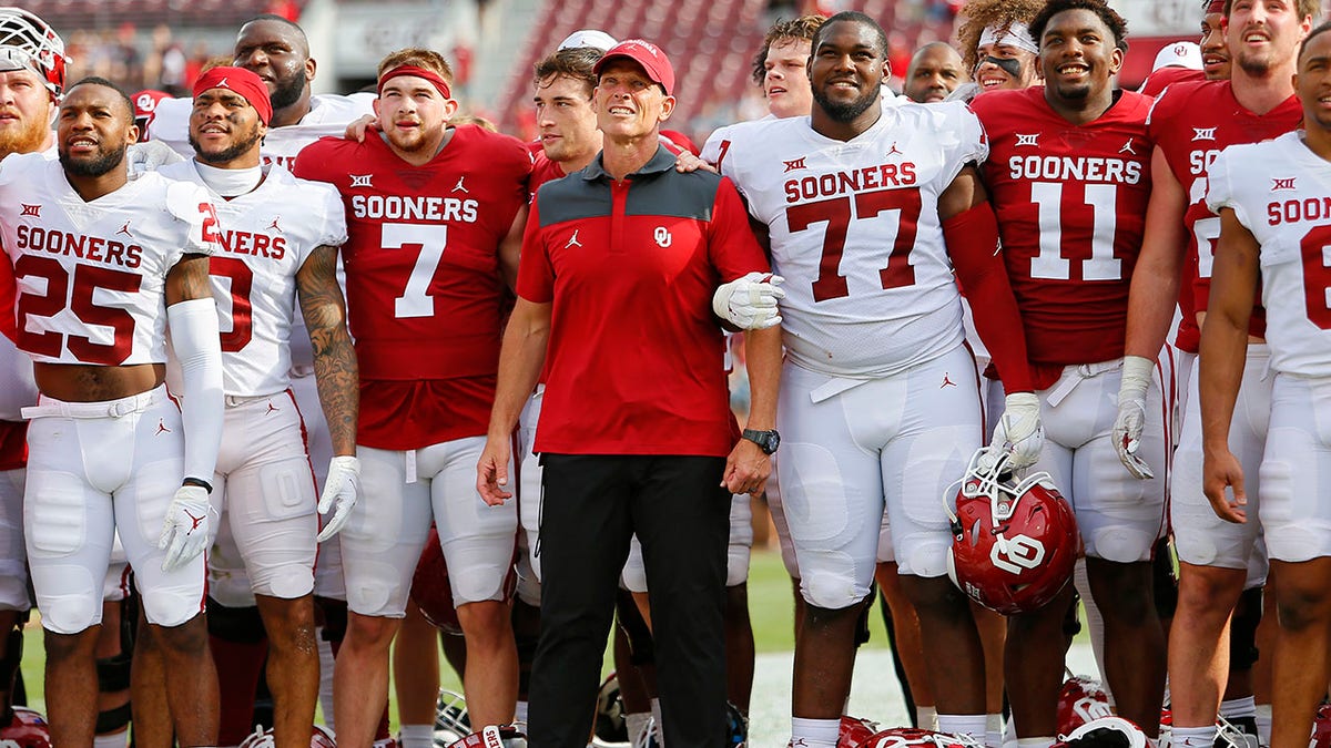 First-year OU head coach Brent Venables with team in jerseys reading "Sooners"