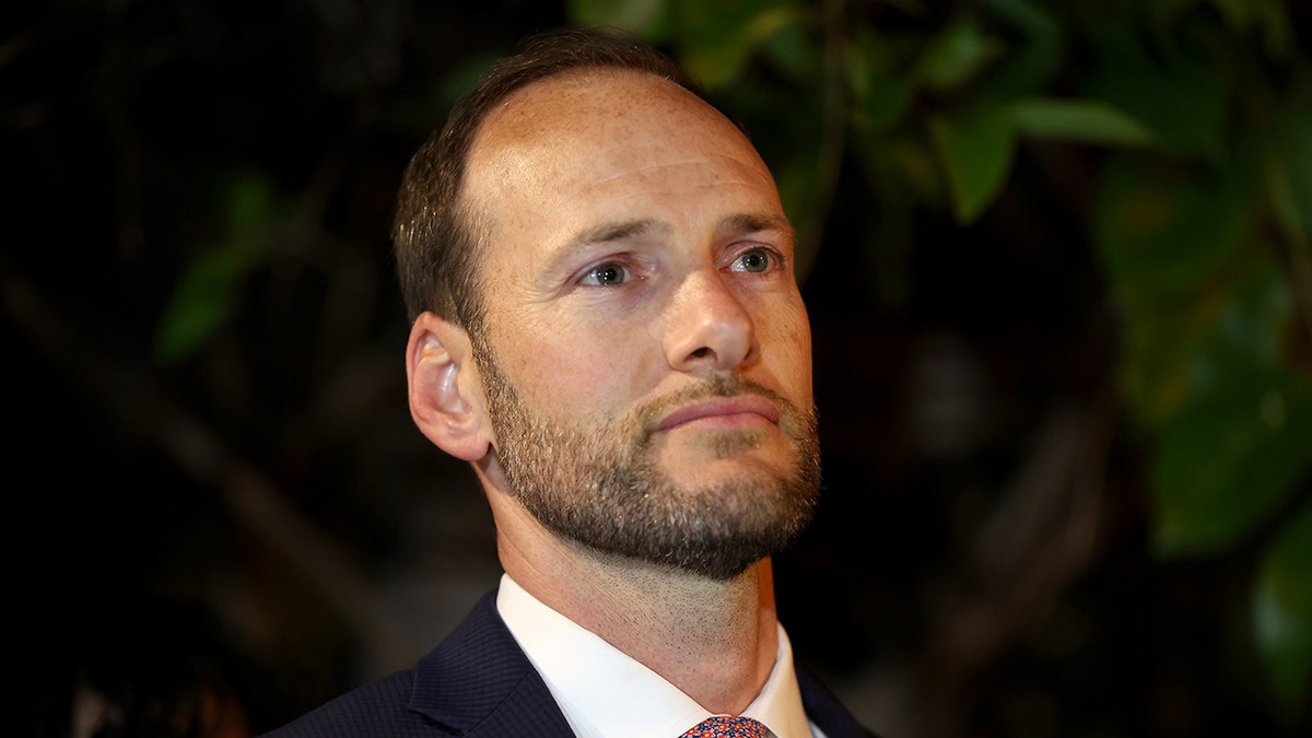 Chesa Boudin photographed outside at night wearing a suit and a close-cropped beard