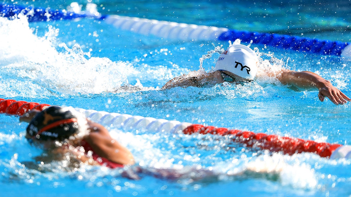 Katie Ledecky swims past an opponent in the 800m free