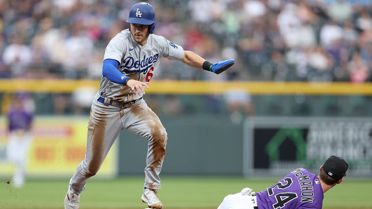 Trea Turner of the Dodgers scores after a Rockies error
