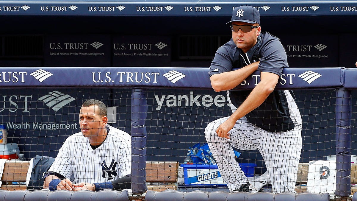 Derek Jeter and Alex Rodriguez look on during a 2013 game