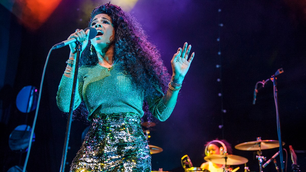 A photo of Kelis singing with a microphone