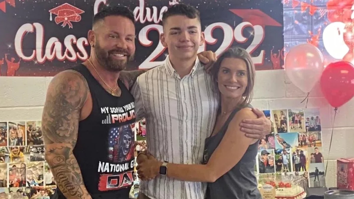 Deceased Jacob Hills poses with his parents at a graduation party
