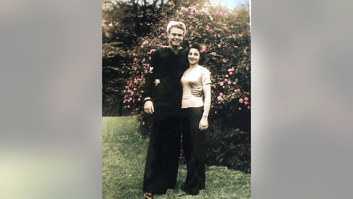 Hubert and June Malicote in front of rose bush