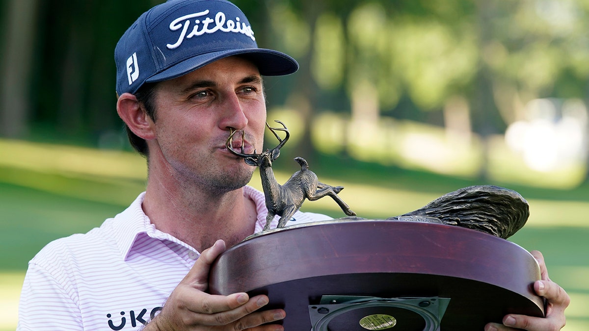 JT Poston kisses the John Deere Classic tropy