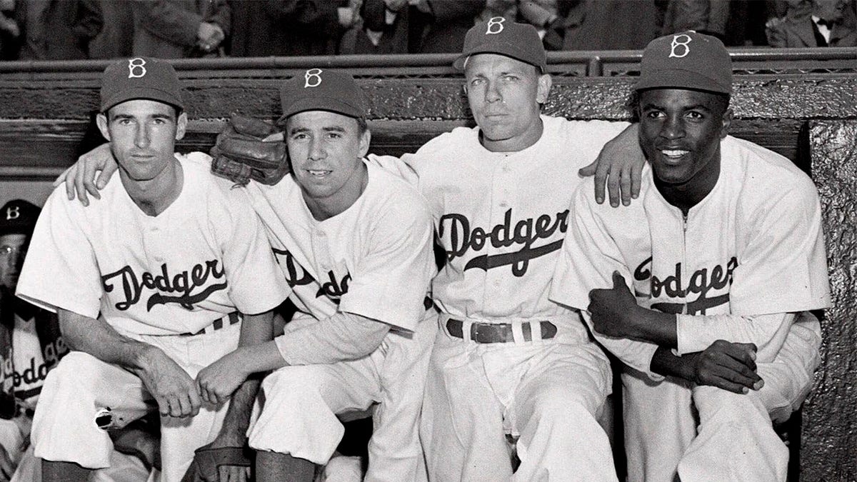 Josh Jorgensen, Pee Wee Reese, Ed Stanky, and Jackie Robinson sitting in the dugout