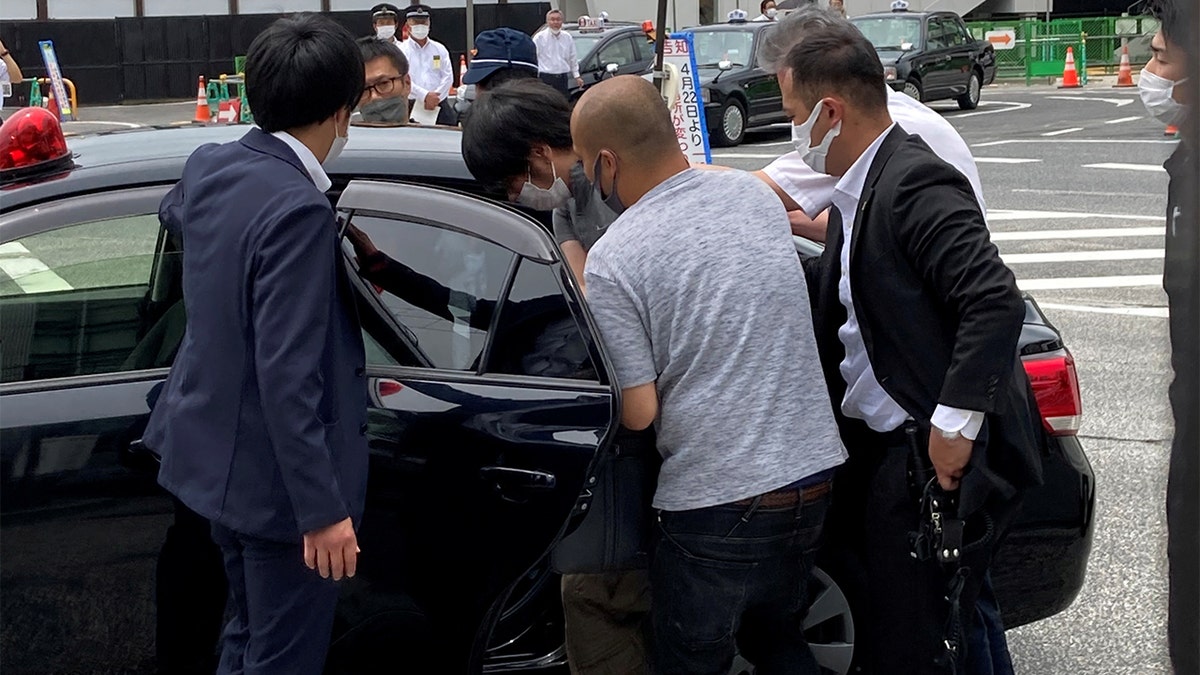 Shinzo Abe shooting suspect is taken into custody by police officers