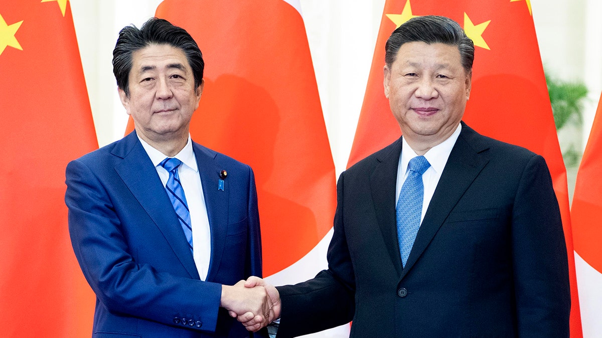Japan's Shinzo Abe shakes hands with China's Xi Jinping