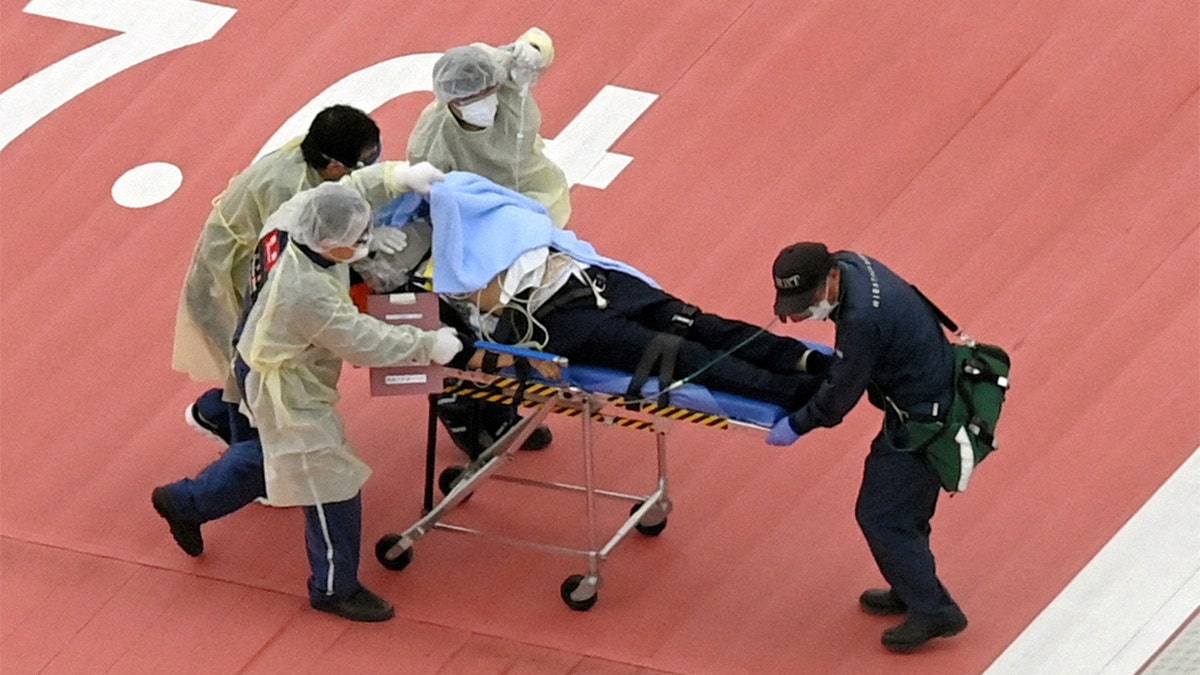 Man on stretcher is rushed to hospital after former Japanese Prime Minister Shinzo Abe was shot