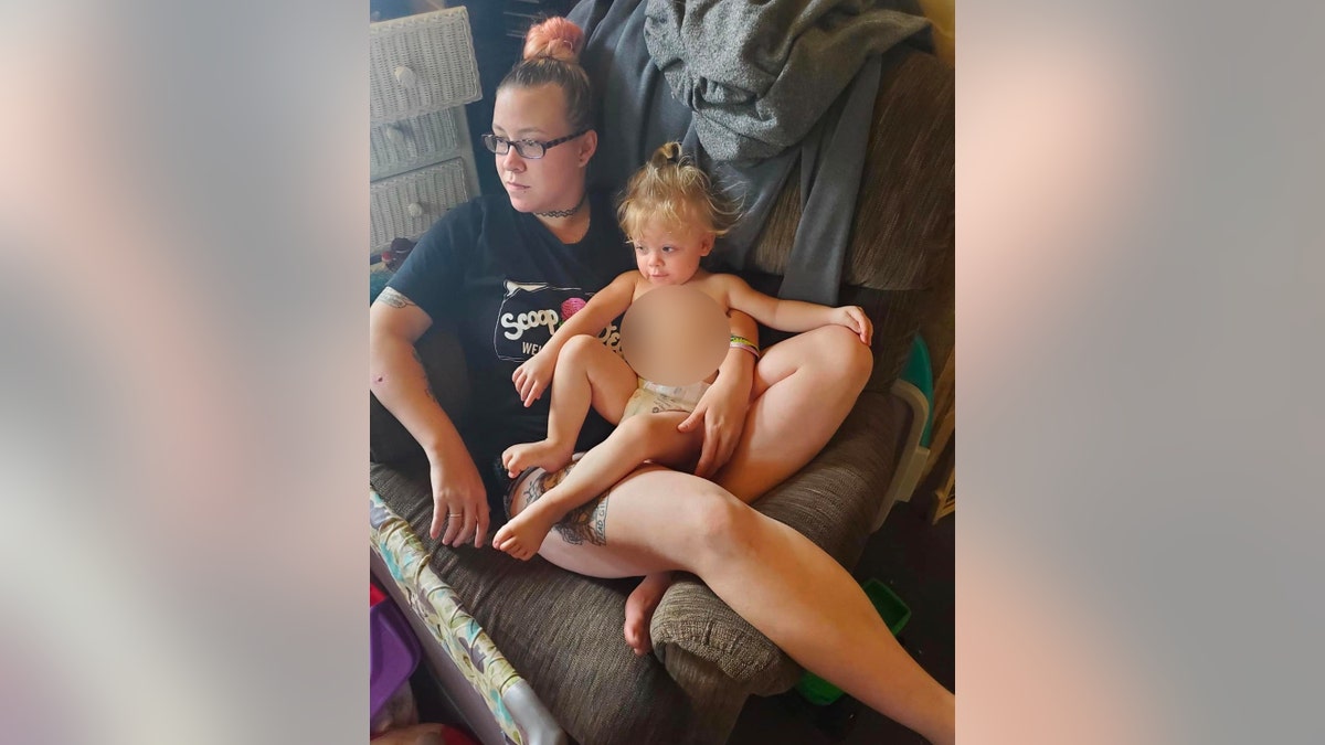 Jill Sidebotham holds her daughter Lydia Hansen in her lap