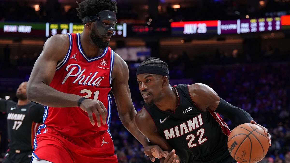 Jimmy Butler drives past Joel Embiid